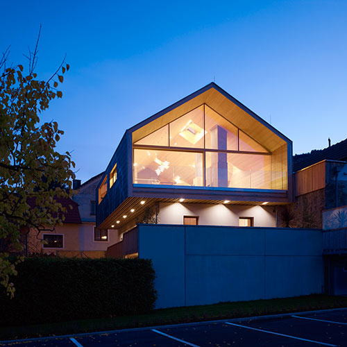 House facade with large panorama windows lit from within