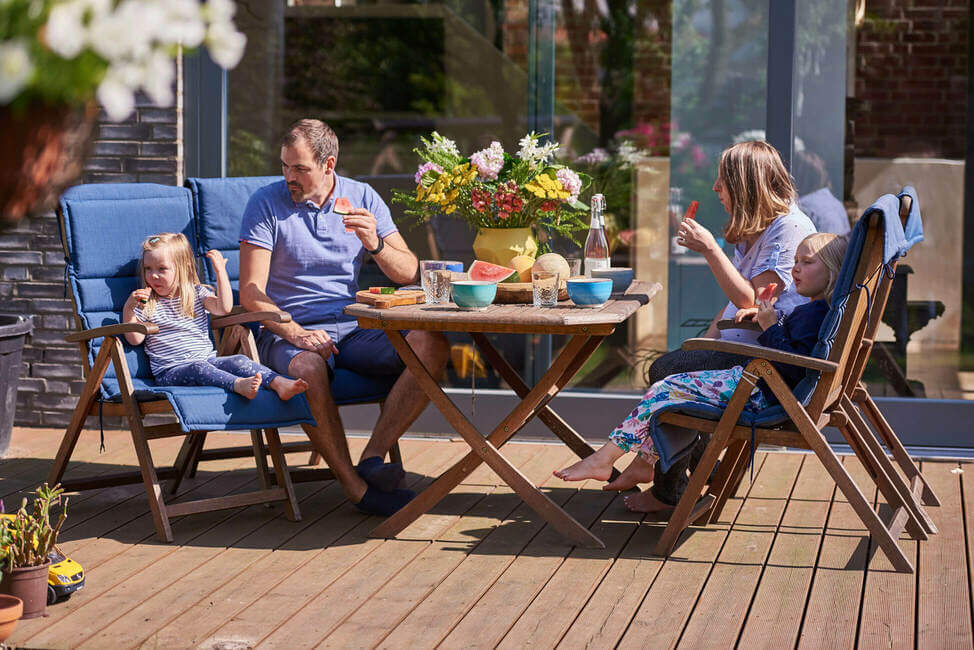 Image of a family sitting in the terrace by the table
