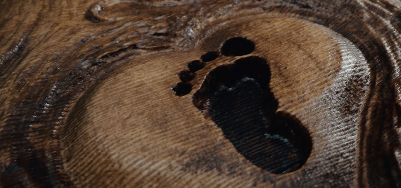 Image of footprint carved in a wooden table