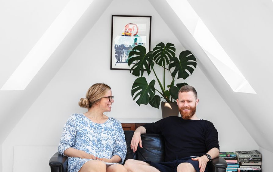 Young, happy couple that have just installed new VELUX roof windows in their appartment. 