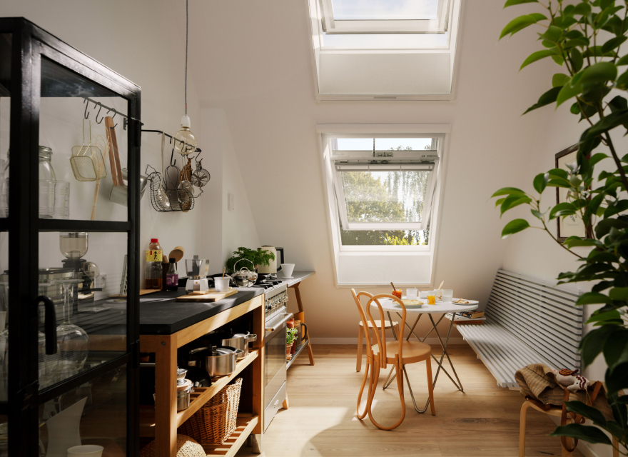 Cozy, open kitchen with a small kitchen table and two VELUX roof windows installed in the roof.