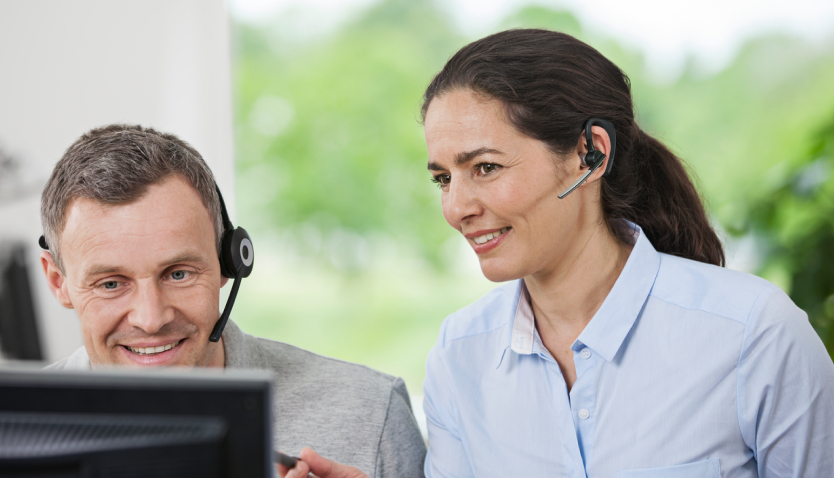 Woman and man at VELUX call center helping customers with after sales support.