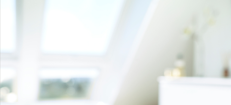 Bright, white bedroom with four VELUX roof windows.