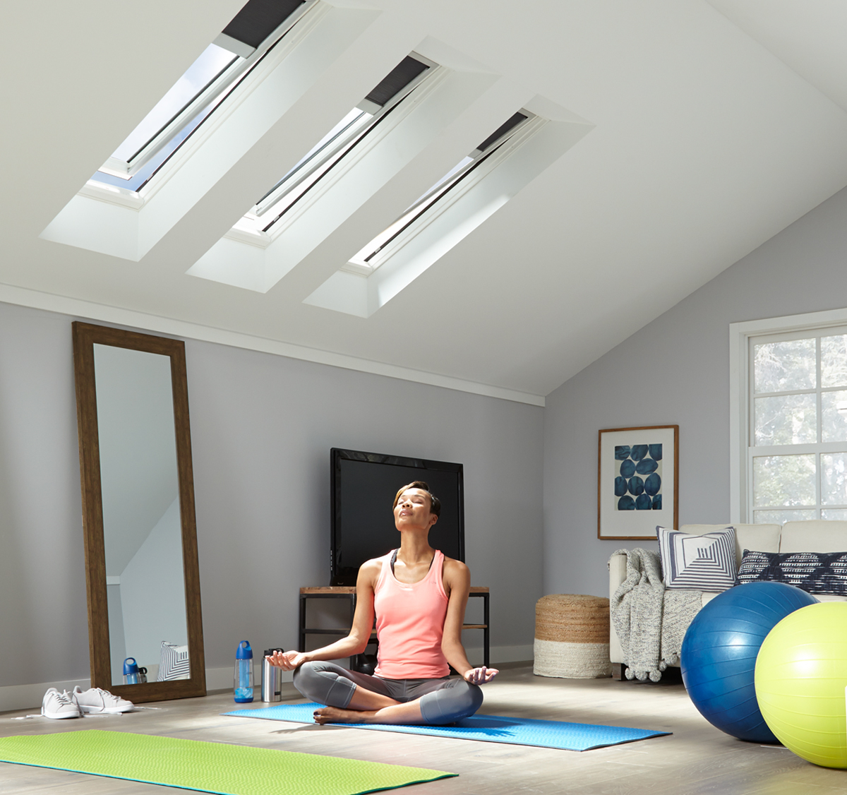 A woman meditating in her yoga room with VELUX Skylights.
