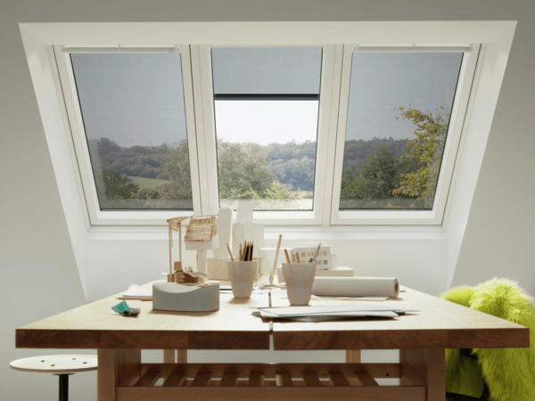 Image of wooden dining table with three roof windows installed above, accessorized with awning blinds