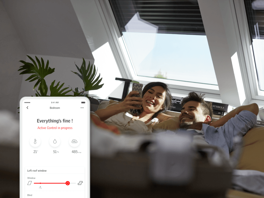 Image of couple laying in bed, both looking at the woman's smartphone