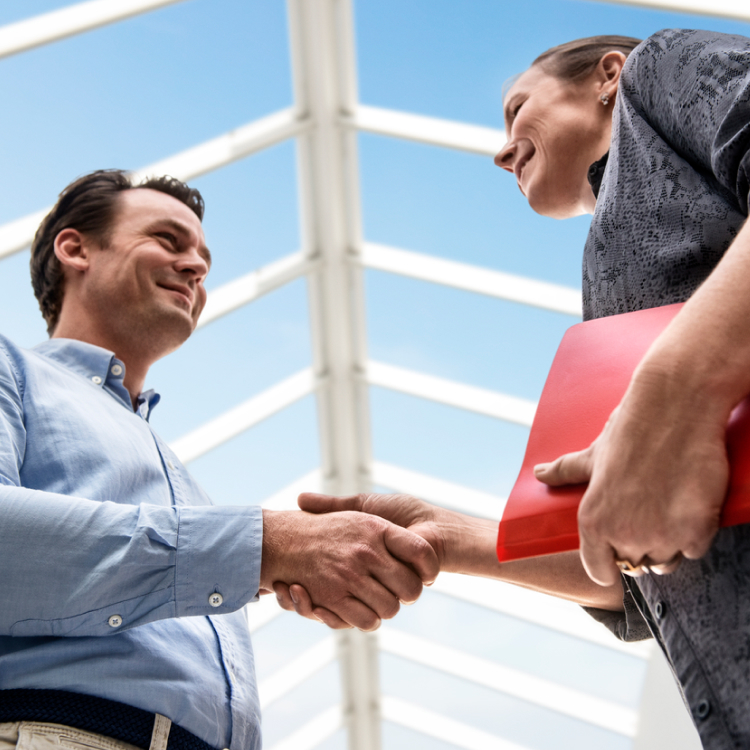 Two men greet each other under a modular skylights.