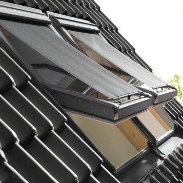 Outside view of two open VELUX roof windows with VELUX awning blinds attached.