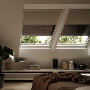 Two VELUX soft shutters and grey VELUX blackout blinds are covering two VELUX roof windows.