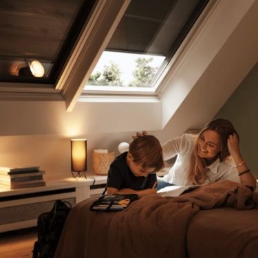 Bedroom with roof windows covered with blinds