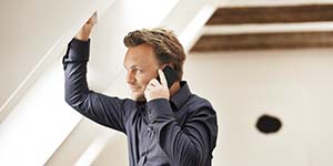 man speaking on phone underneath a VELUX roof window