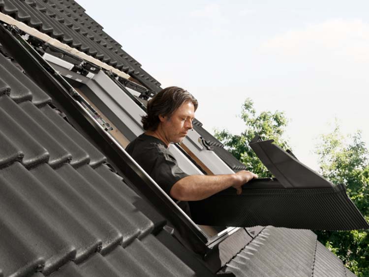 VELUX certified installer installing roof windows in black tiled roof